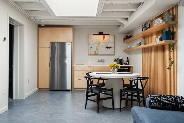 dining area featuring baseboards and concrete floors