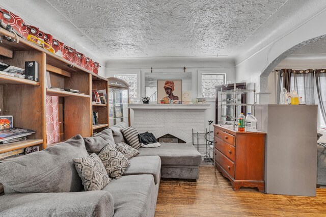 15885 Indiana St, Detroit, MI 48238 - living room featuring arched walkways, a textured ceiling, wood finished floors, and a healthy amount of sunlight