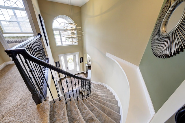 51583 Turnburry Dr, South Lyon, MI 48178 - stairway with carpet flooring, a high ceiling, a chandelier, and baseboards