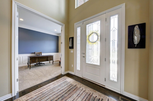 51583 Turnburry Dr, South Lyon, MI 48178 - entrance foyer featuring dark wood-type flooring, wainscoting, crown molding, and a decorative wall