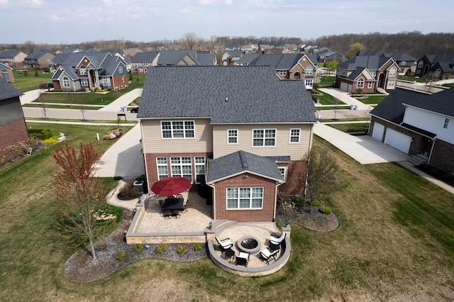 51583 Turnburry Dr, South Lyon, MI 48178 - rear view of property featuring brick siding, a residential view, a patio area, and an outdoor fire pit