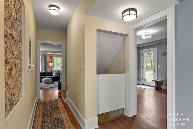 hall with baseboards, wood finished floors, and a wealth of natural light