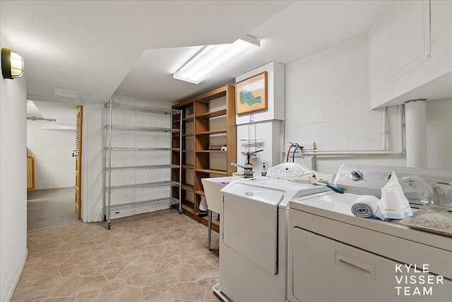 laundry room featuring a sink, laundry area, stone finish floor, and washer and clothes dryer