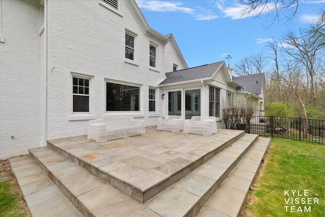 back of house featuring a sunroom, a patio area, and fence
