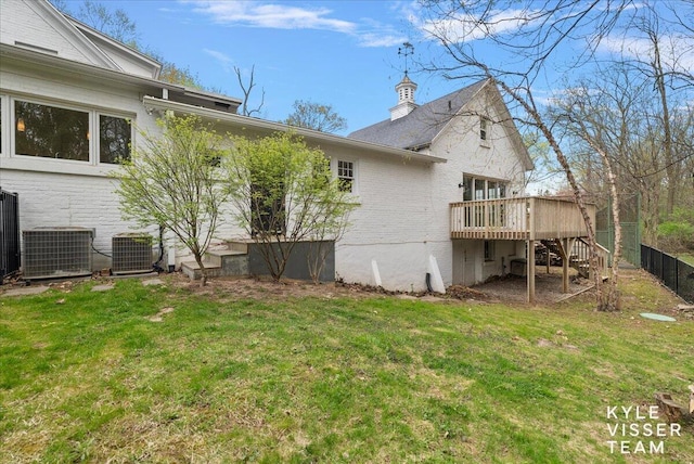 rear view of house with stairs, central AC unit, a wooden deck, and a yard