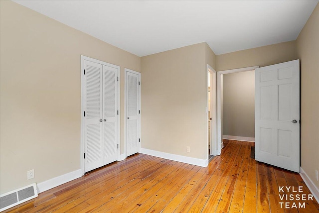 unfurnished bedroom featuring visible vents, baseboards, and light wood-type flooring