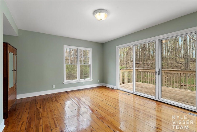 spare room featuring baseboards and wood-type flooring