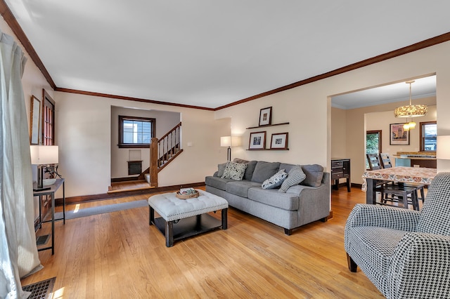 1115 Henry St, Ann Arbor, MI 48104 - living room with light wood-style flooring, plenty of natural light, stairs, ornamental molding, and a chandelier
