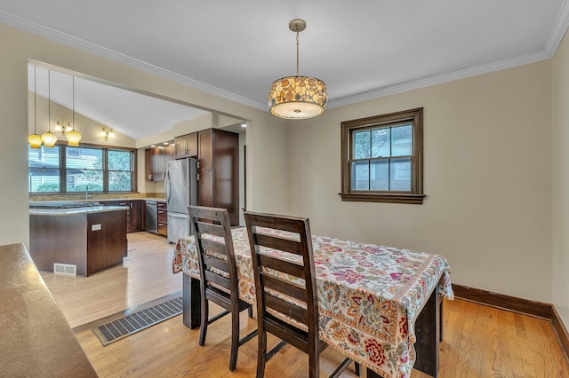 1115 Henry St, Ann Arbor, MI 48104 - dining room with healthy amount of natural light, light wood finished floors, ornamental molding, and vaulted ceiling