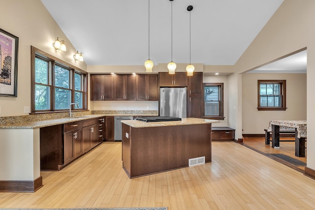 1115 Henry St, Ann Arbor, MI 48104 - kitchen with stainless steel appliances, dark brown cabinetry, a center island, decorative light fixtures, and high vaulted ceiling