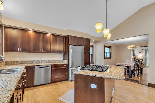 1115 Henry St, Ann Arbor, MI 48104 - kitchen featuring stainless steel appliances, hanging light fixtures, light wood finished floors, a center island, and light stone countertops