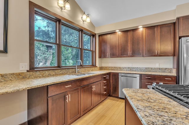 1115 Henry St, Ann Arbor, MI 48104 - kitchen featuring appliances with stainless steel finishes, light wood finished floors, light stone counters, and vaulted ceiling