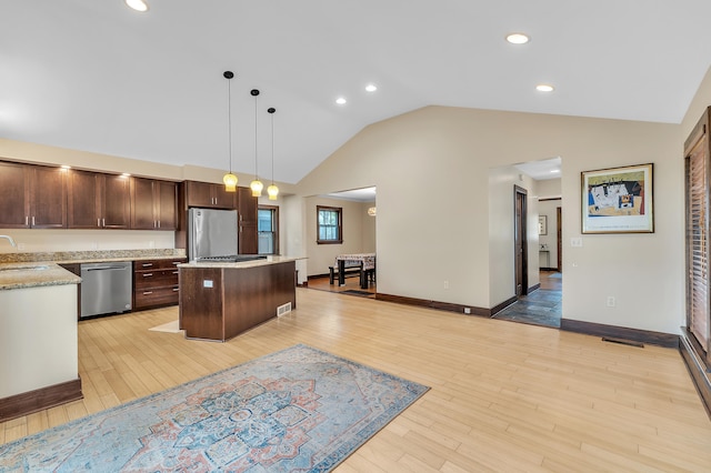 1115 Henry St, Ann Arbor, MI 48104 - kitchen featuring appliances with stainless steel finishes, a kitchen island, dark brown cabinets, light wood-style floors, and pendant lighting
