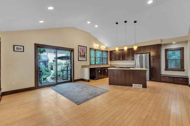 1115 Henry St, Ann Arbor, MI 48104 - kitchen featuring freestanding refrigerator, dark brown cabinetry, a kitchen island, lofted ceiling, and hanging light fixtures