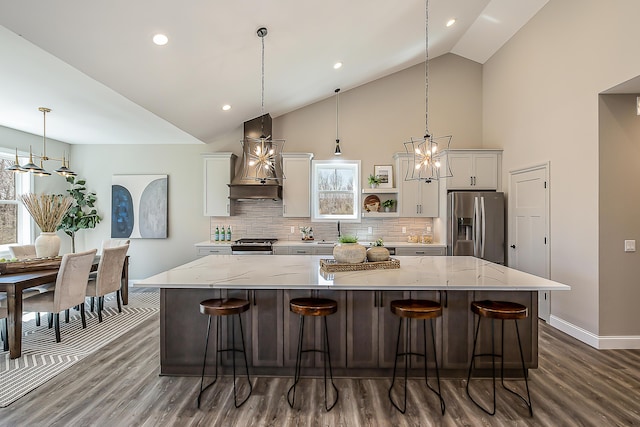 5215 Grande View Ln, Jackson, MI 49201 - kitchen with wall chimney range hood, white cabinets, appliances with stainless steel finishes, an inviting chandelier, and baseboards