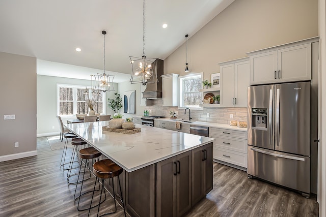 5215 Grande View Ln, Jackson, MI 49201 - kitchen with backsplash, a center island, high vaulted ceiling, an inviting chandelier, and stainless steel appliances