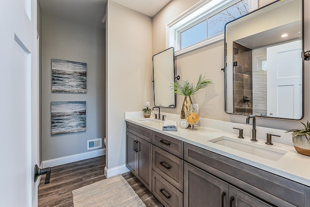 5215 Grande View Ln, Jackson, MI 49201 - full bathroom featuring a sink, a tile shower, wood finished floors, and visible vents