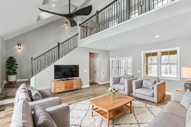 5182 Grande View Ln, Jackson, MI 49201 - living room featuring ceiling fan, stairs, baseboards, wood finished floors, and a towering ceiling