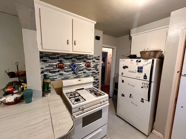 kitchen with light countertops, tasteful backsplash, white appliances, and white cabinets