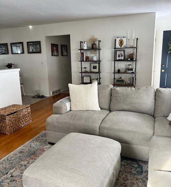 living area featuring visible vents and wood finished floors