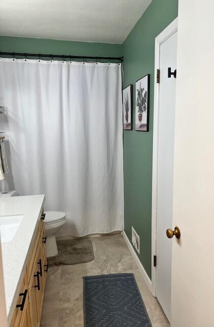 bathroom with toilet, curtained shower, and vanity