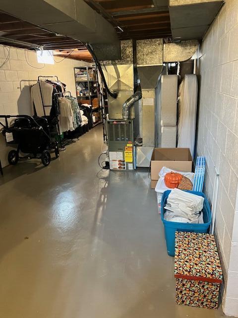 unfinished basement with concrete block wall and heating unit