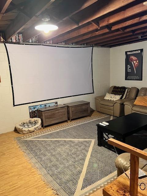 cinema featuring wood finished floors and concrete block wall