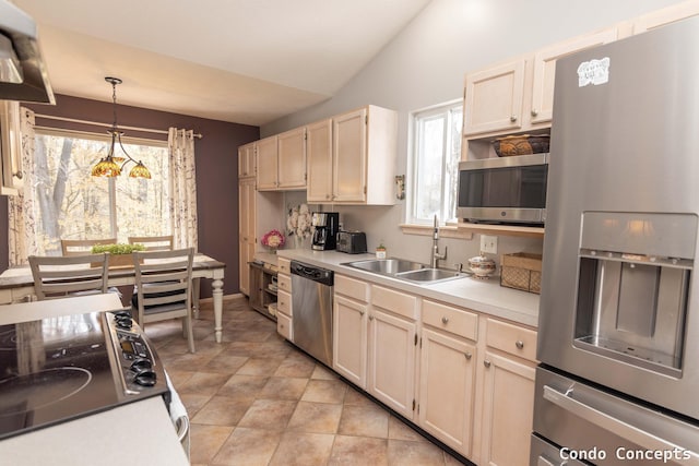 kitchen featuring a sink, wall chimney exhaust hood, stainless steel appliances, decorative light fixtures, and lofted ceiling