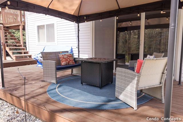 wooden deck featuring a gazebo, an outdoor living space with a fire pit, and stairway