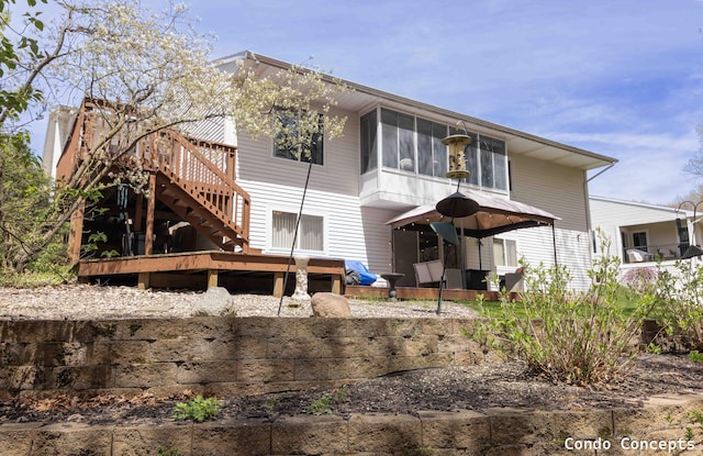 rear view of house with a wooden deck and stairway
