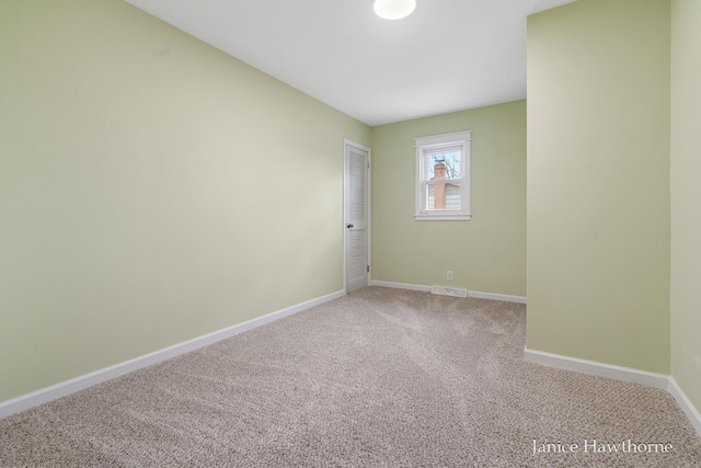 unfurnished room featuring light colored carpet, visible vents, and baseboards