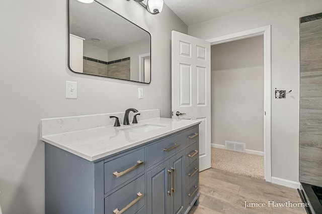 full bath featuring baseboards, visible vents, wood finished floors, and vanity