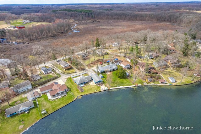 drone / aerial view with a residential view, a water view, and a forest view