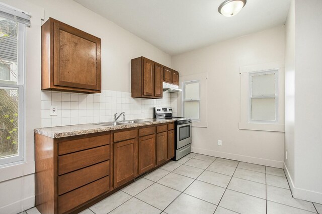 311 Robey Pl SE, Grand Rapids, MI 49506 - kitchen with under cabinet range hood, light countertops, a sink, baseboards, and stainless steel electric stove