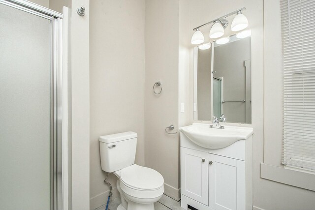 311 Robey Pl SE, Grand Rapids, MI 49506 - bathroom with toilet, a shower with shower door, vanity, and baseboards