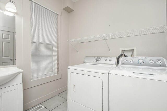 311 Robey Pl SE, Grand Rapids, MI 49506 - washroom featuring laundry area, light tile patterned floors, washing machine and dryer, baseboards, and visible vents
