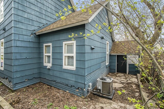 311 Robey Pl SE, Grand Rapids, MI 49506 - view of side of property with an outdoor structure, a storage shed, central air condition unit, and a shingled roof