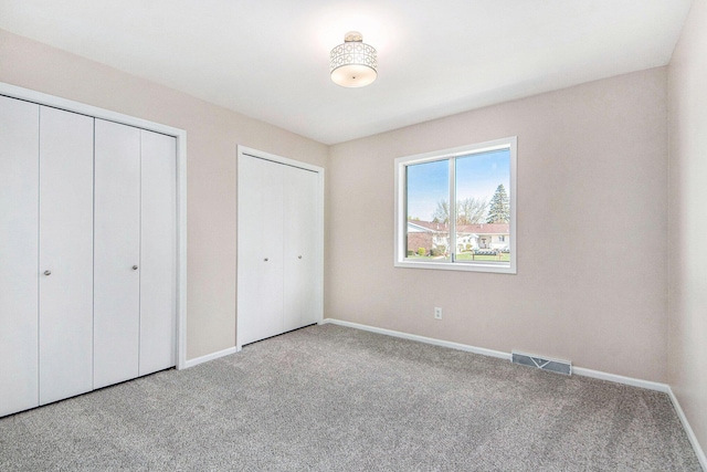 5984 Leisure S Dr SE, Grand Rapids, MI 49548 - unfurnished bedroom with multiple closets, baseboards, carpet, and visible vents