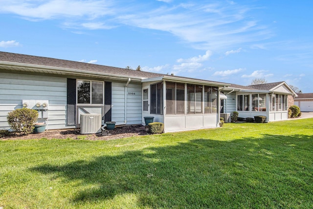 5984 Leisure S Dr SE, Grand Rapids, MI 49548 - back of house with central air condition unit, a lawn, a shingled roof, and a sunroom