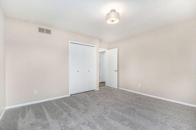 5984 Leisure S Dr SE, Grand Rapids, MI 49548 - unfurnished bedroom featuring visible vents, baseboards, carpet floors, and a closet