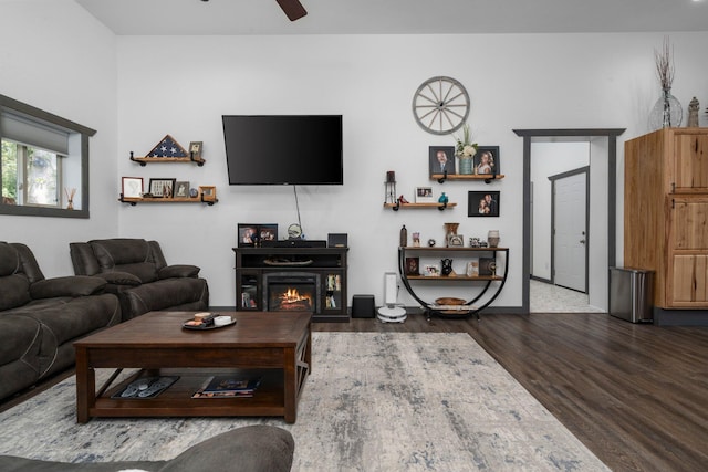 9528 Lee Rd, Jackson, MI 49201 - living room with a warm lit fireplace, ceiling fan, baseboards, and wood finished floors