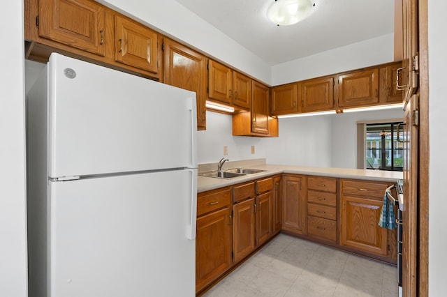 5160 Green Meadow Rd, Kalamazoo, MI 49009 - kitchen with a sink, freestanding refrigerator, and brown cabinets