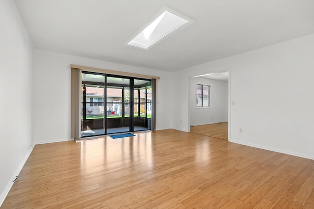 5160 Green Meadow Rd, Kalamazoo, MI 49009 - unfurnished room with a skylight, baseboards, and light wood-style floors