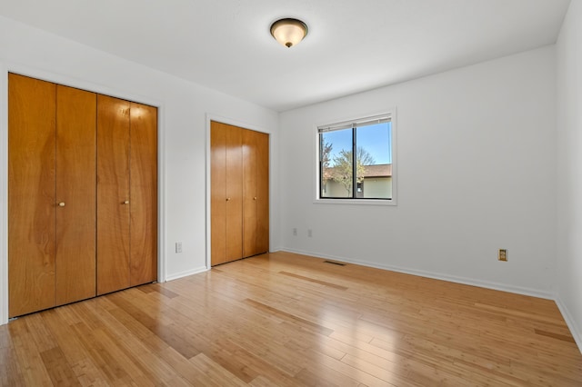 5160 Green Meadow Rd, Kalamazoo, MI 49009 - unfurnished bedroom with light wood-type flooring, baseboards, two closets, and visible vents