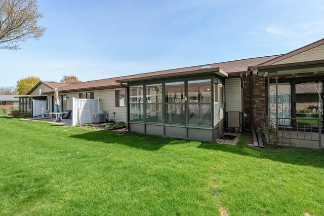 5160 Green Meadow Rd, Kalamazoo, MI 49009 - back of house featuring a sunroom, central AC unit, and a lawn