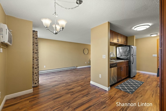 kitchen featuring appliances with stainless steel finishes, a baseboard radiator, dark wood-style floors, and a sink