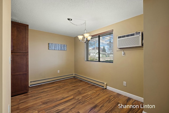 unfurnished room with baseboards, baseboard heating, dark wood-style floors, a wall unit AC, and a notable chandelier
