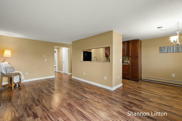 unfurnished living room featuring a chandelier, dark wood-type flooring, baseboards, a textured ceiling, and a baseboard radiator