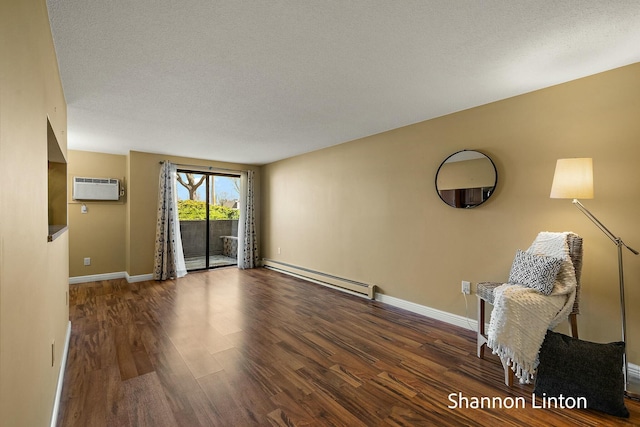 unfurnished living room featuring baseboard heating, baseboards, wood finished floors, and an AC wall unit