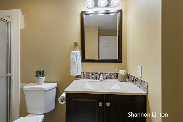 bathroom featuring toilet, vanity, and decorative backsplash